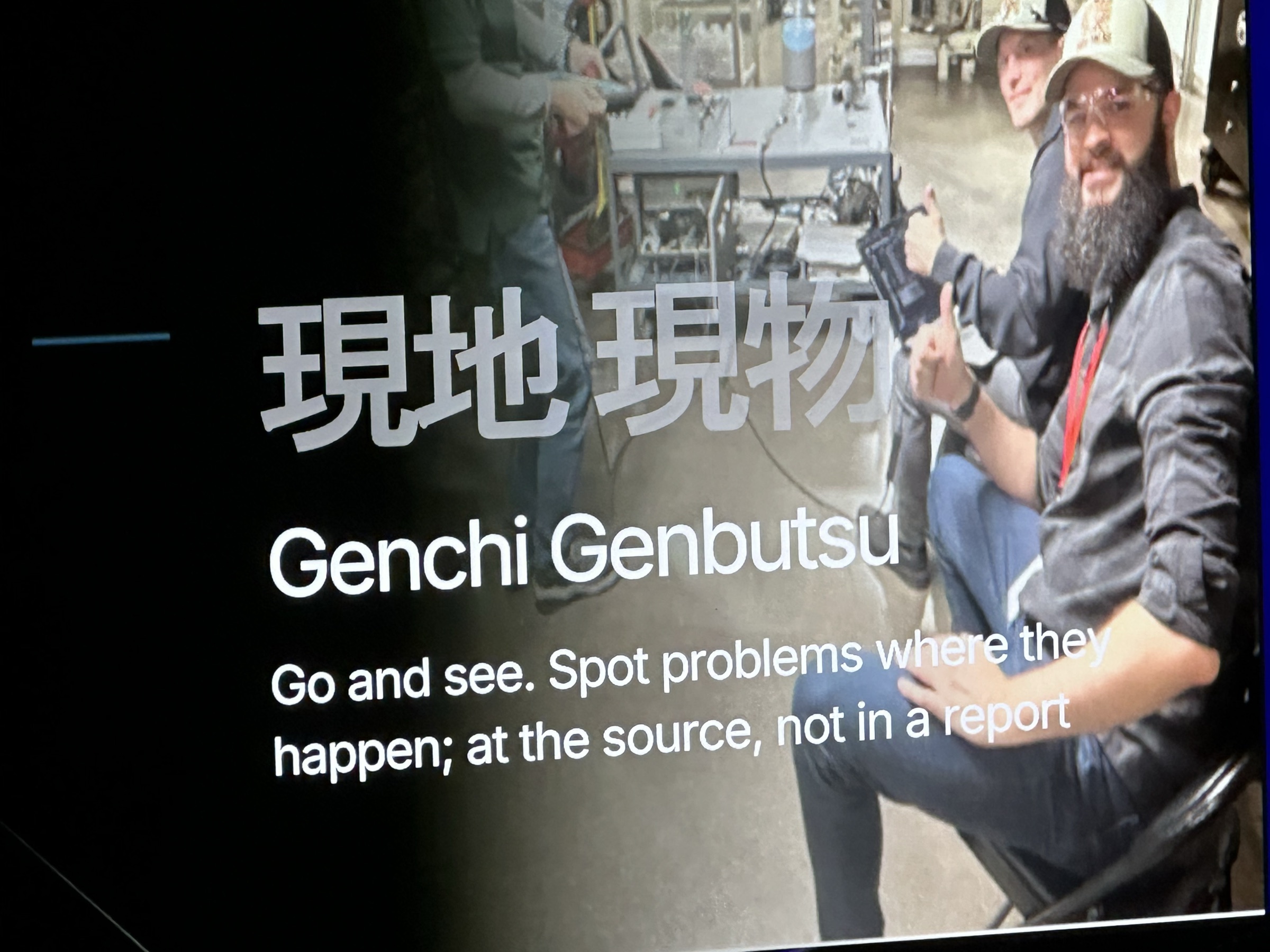Toyota slide of Genchi Genbutsu — go and see — over a photo of engineers on the factory floor